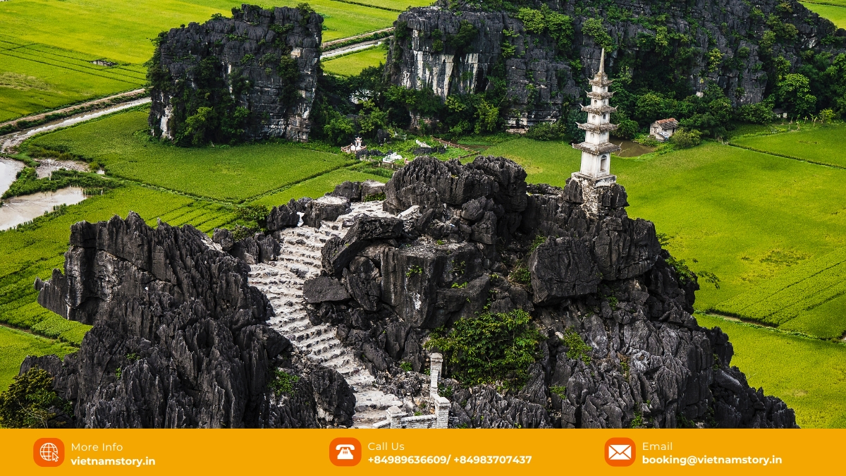 A tourist overlooks the misty limestone karsts from Mua Caves viewpoint, Ninh Binh, in cool November weather. A tourist overlooks the misty limestone karsts from Mua Caves viewpoint, Ninh Binh, in cool November weather.